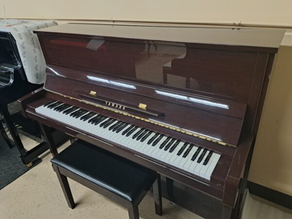 This is a picture of a used Yamaha B3 upright piano. It has a polished mahogany finish.