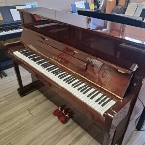 Kawai CX-15 upright piano in a polished mahogany finish.